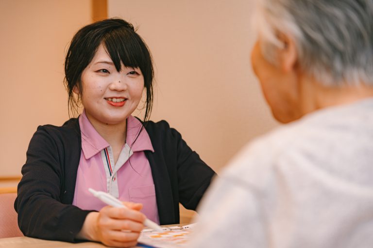 介護職員が高齢入居者と笑顔でコミュニケーションを取る様子